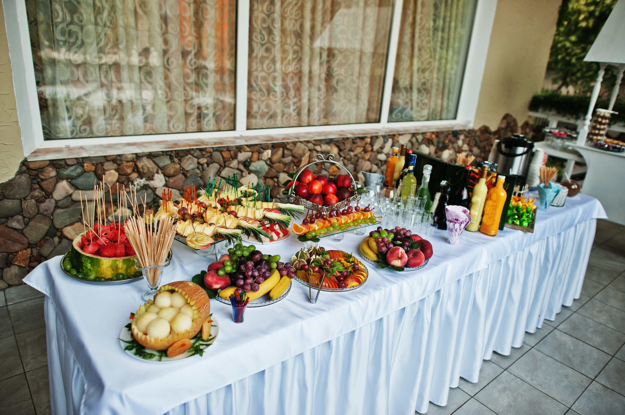 Table catering with different fruits such as watermelon, pineapple at wedding reception.